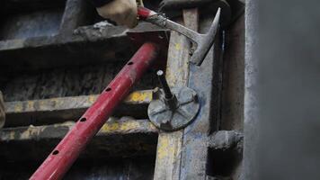 Worker adjusting formwork connection with hammer video