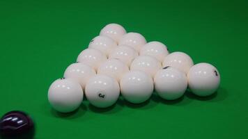 A neat arrangement of stacked pool balls sits on the classic green table, ready for play video