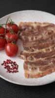 Crispy fried pork bacon sliced with salt, spices and herbs on dark concrete background video