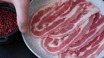 Fresh raw bacon sliced with spices and herbs on a dark concrete background video