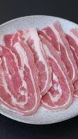 Fresh raw bacon sliced with spices and herbs on a dark concrete background video