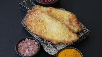 Grilled chicken or turkey chop with salt, spices and herbs on a dark concrete background video
