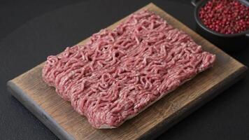 Fresh raw ground minced beef with salt and spices on textured concrete background video