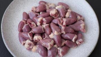 Raw chicken hearts with salt, spices and herbs on a dark concrete background video