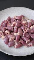 Raw chicken hearts with salt, spices and herbs on a dark concrete background video