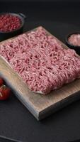 Fresh raw ground minced beef with salt and spices on textured concrete background video
