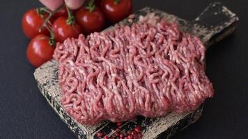 Fresh raw ground minced beef with salt and spices on textured concrete background video