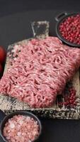 Fresh raw ground minced beef with salt and spices on textured concrete background video