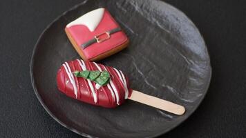 Natural popsicle ice cream on a stick covered with chocolate in the style and colors of Christmas and New Year on a dark concrete background video