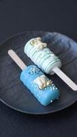 Natural popsicle ice cream on a stick covered with chocolate in the style and colors of Christmas and New Year on a dark concrete background video