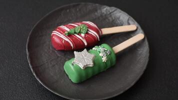 Natural popsicle ice cream on a stick covered with chocolate in the style and colors of Christmas and New Year on a dark concrete background video