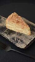 Piece of sweet layer cake Napoleon with custard on a dark concrete background video
