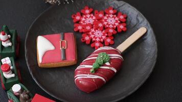 Natural popsicle ice cream on a stick covered with chocolate in the style and colors of Christmas and New Year on a dark concrete background video