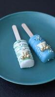 Natural popsicle ice cream on a stick covered with chocolate in the style and colors of Christmas and New Year on a dark concrete background video