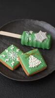 Natural popsicle ice cream on a stick covered with chocolate in the style and colors of Christmas and New Year on a dark concrete background video