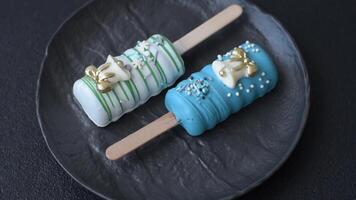 Natural popsicle ice cream on a stick covered with chocolate in the style and colors of Christmas and New Year on a dark concrete background video