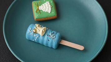 Natural popsicle ice cream on a stick covered with chocolate in the style and colors of Christmas and New Year on a dark concrete background video