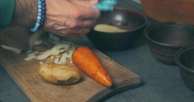 A person is cutting up a carrot on a cutting board video