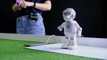 Engineer programming humanoid robot showing movements in slow motion video