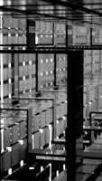 A black and white of a long, welllit hallway with windows. Design video