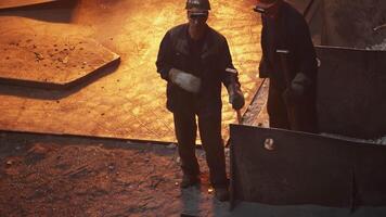 Workers Handling Molten Metal in a Busy Foundry, Showcasing Skills and Techniques. Stock Clip video