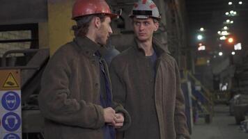 Workers in an industrial setting are engaged in productive conversations about their tasks. Stock Clip video