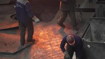 Workers who are engaged in handling molten material in an industrial foundry setting. Stock Clip video