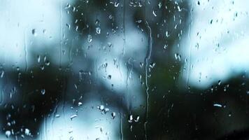 Rain drops flow on the window in the daytime video