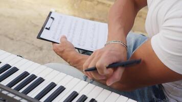 Man Prepares Musical Chords On The Keyboard And Marks The Notes In The Score video