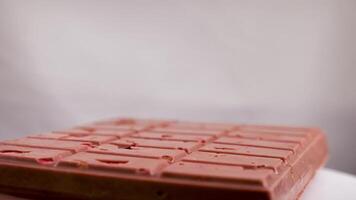A bar of pink ruby chocolate with freeze-dried strawberries and almonds close-up. A healthy dessert based on berries and nuts video