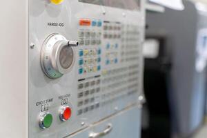 Closeup and crop control buttons center of automated CNC vertical machine. photo