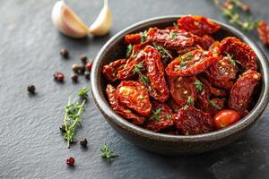 Sun-dried tomatoes packed in a bowl with herbs and spices on a kitchen countertop ready for use in culinary photo