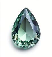 Sparkling teal gemstone in a tear drop shape illuminated by soft light showing intricate cuts and reflections on photo