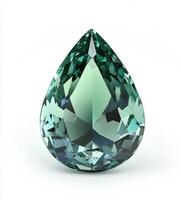 Sparkling teal gemstone in a tear drop shape illuminated by soft light showing intricate cuts and reflections on photo