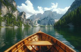Serene lake view from wooden boat surrounded by majestic mountains and lush greenery during a sunny day photo