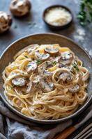 Creamy fettuccine pasta with mushrooms and herbs served in a rustic bowl, perfect for a comforting meal at home photo