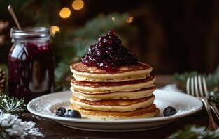 Fluffy pancakes stacked high with blueberry compote and fresh berries on a rustic wooden table photo