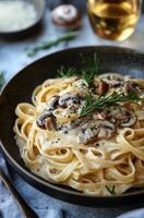 Creamy fettuccine pasta with mushrooms and herbs served in a rustic bowl, perfect for a comforting meal at home photo