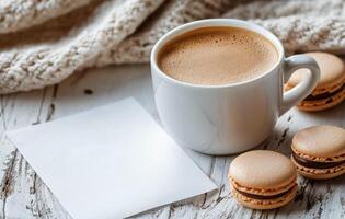Coffee cup rests next to macaroons and scattered coffee beans on a cozy knit blanket during a leisurely photo
