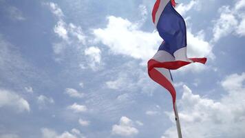 Thailand s national flag is blowing with the wind and clouds on the blue sky. It is composed of horizontal lines of red, white, blue, white and red. video