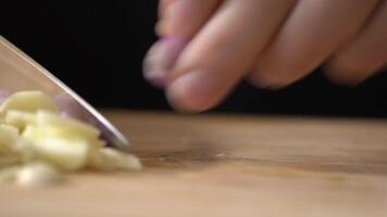 Slicing Shallot, red onion on a wooden cutting board into slice pieces with a kitchen knife by professional chef. video