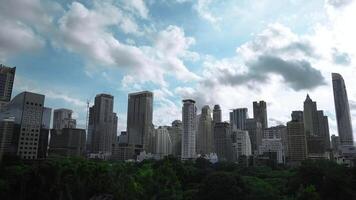 Timelapse of Building with Green area in front of the middle of Bangkok metropolis with high building all around in the open sky. video