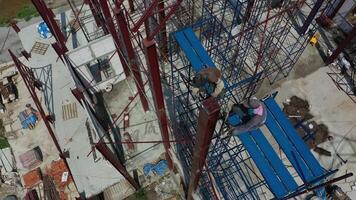 Dual Asian Welder and blacksmith work on the height scaffolding, Shoot from above of them. video
