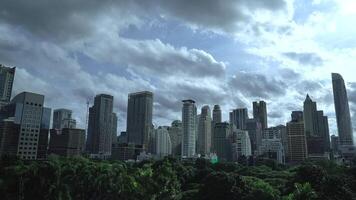 Timelapse of Building with Green area in front of the middle of Bangkok metropolis with high building all around in the open sky. video