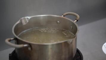 Chicken Broth soup is boiling on the gas strove with a little oil on surface of it. video