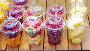 A colorful assortment of fresh mixed fruits served in cups on a checkered tablecloth video