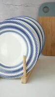 une charmant et élégant afficher de bleu et blanc assiettes sur une en bois supporter video