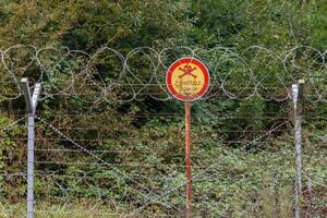 Gilan Province, Iran - September 28, 2024 - This location features a warning sign indicating restricted access along the Iran-Azerbaijan border, surrounded by dense greenery. photo