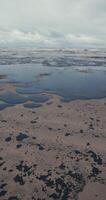 Beach and sea are polluted with oil. Oil spill cleanup. Vertical footage video