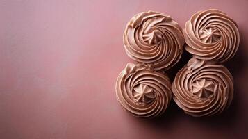 Beautifully decorated chocolate cupcakes arranged on a pink surface during daylight photo